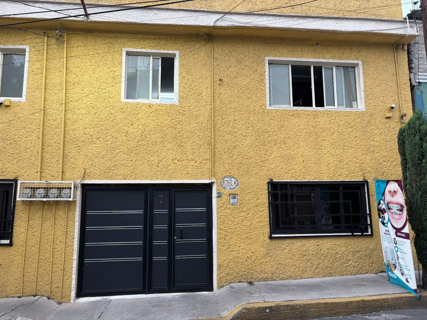 Fachada amarilla del consultorio, número 7